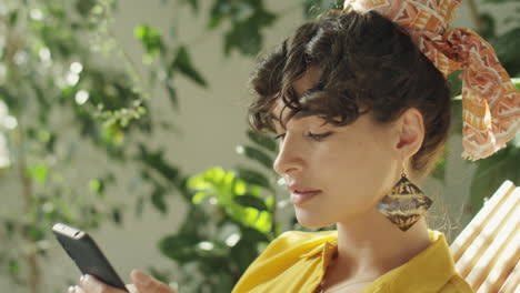 woman using phone in indoor garden