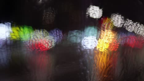 abstract shot from the wet car window on the evening city traffic. hopelessness, fatigue, loneliness concept. rainy autumn weather. slow motion 4k