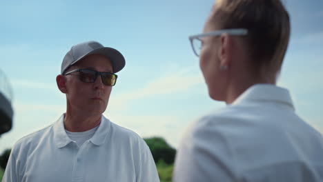 Sport-couple-talk-golf-at-country-club.-Two-players-have-conversation-on-fairway