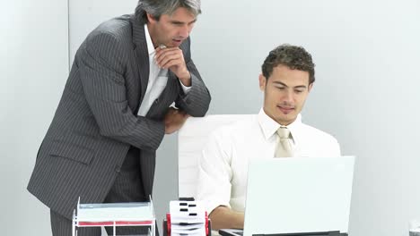 Two-charming-businessmen-working-at-a-laptop