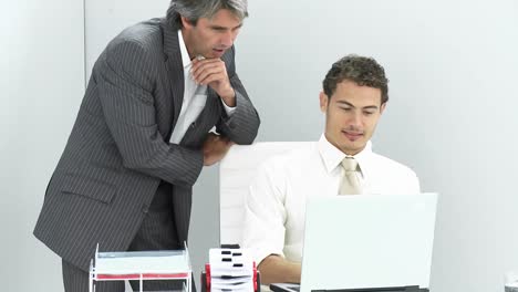 dos hombres de negocios encantadores trabajando en una computadora portátil