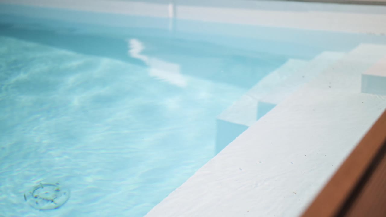 Detalje af trapper til en luksuriøs privat swimmingpool om sommeren med elegant kamerabevægelse