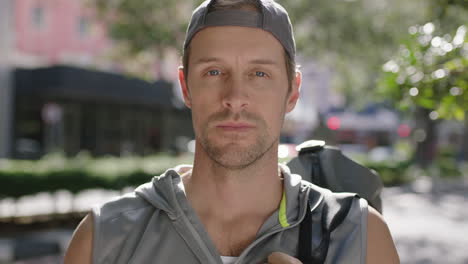 portrait of attractive fit young man wearing sportswear breathing looking pensive on city street