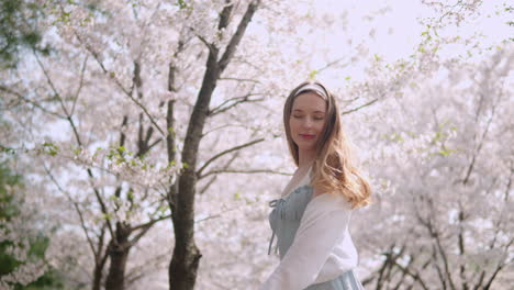 Mujer-Caucásica-Girando-Contra-Los-Cerezos-En-Flor-En-El-Bosque-Ciudadano-De-Yangjae-En-Seocho,-Seúl,-Corea-Del-Sur