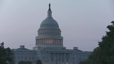 Pan-across-from-a-tree-lined-boulevard-to-the-Capitol-Building-at-dusk