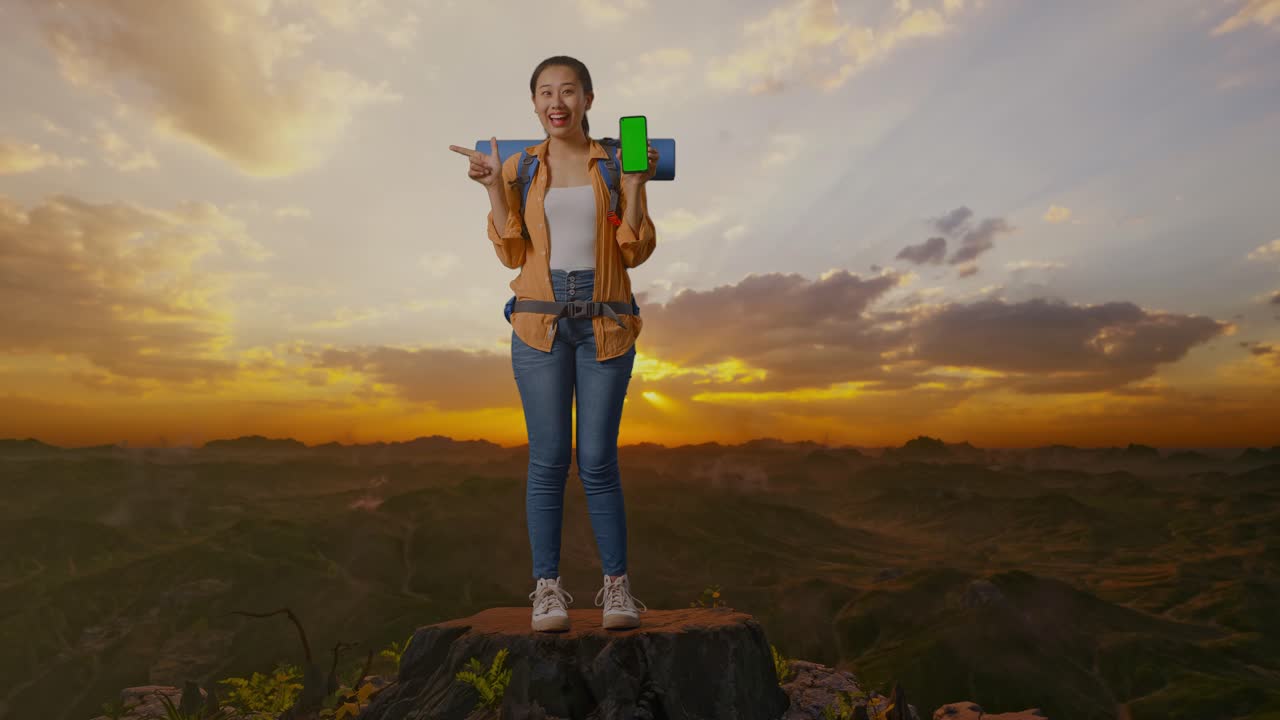 mujer caminando con teléfono de pantalla verde al atardecer
