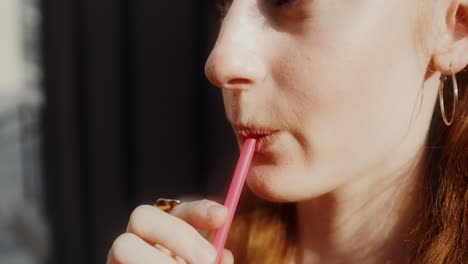 woman drinking with pink straw