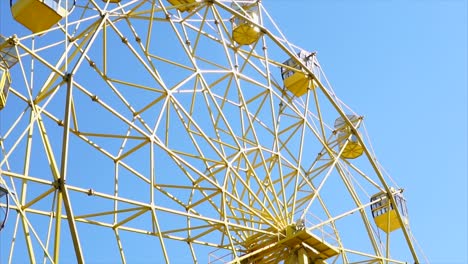 yellow ferris wheel against a blue sky