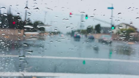 Gotas-De-Lluvia-En-El-Parabrisas-En-Los-Semáforos,-Primer-Plano