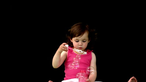 una niña linda soplando burbujas