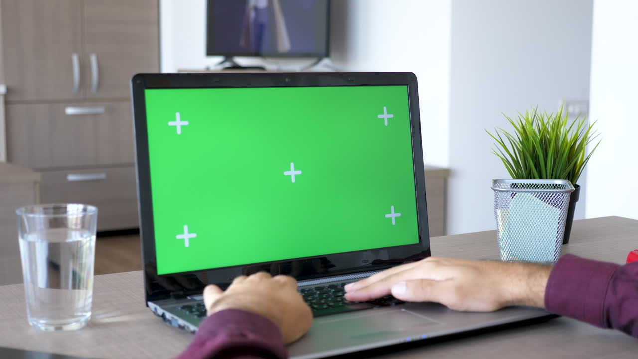 Laptop with Green Screen in Workspace