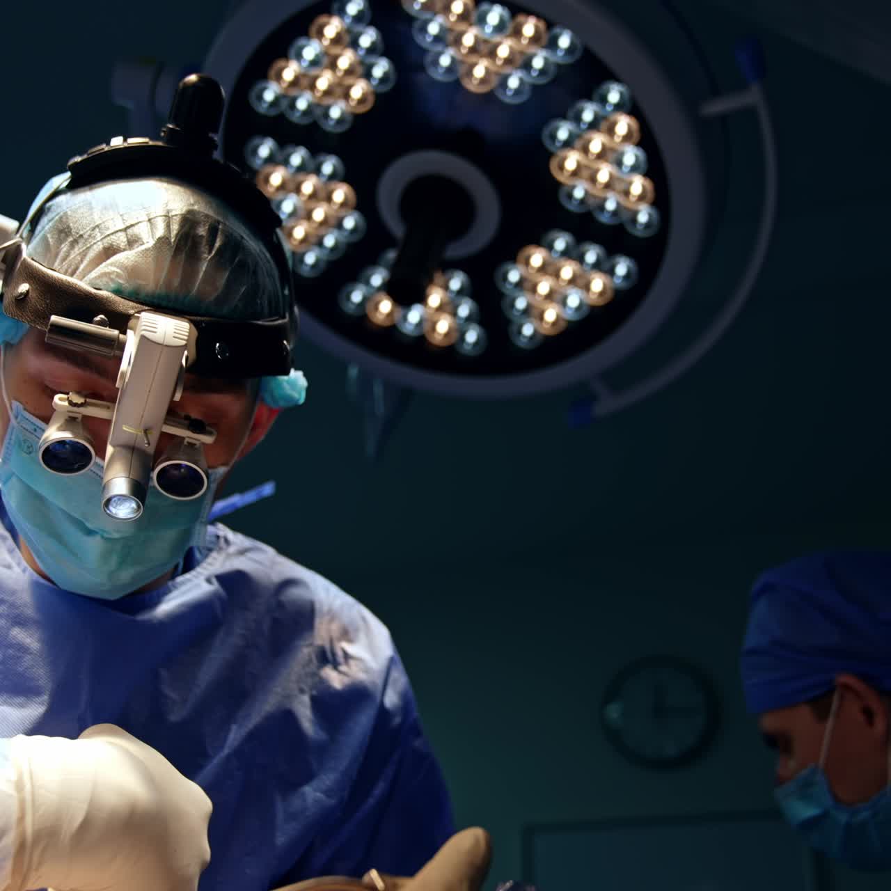 Mandlig neurokirurg med device-briller bruger metalværktøj og drejer det forsigtigt. Portræt af en koncentreret specialist, der udfører kirurgi, set fra en lav vinkel