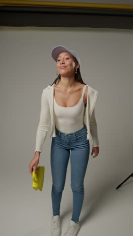 video vertical de una influencer femenina de redes sociales produciendo contenido generado por el usuario en un estudio de modelado variedad de diferentes bolsos de moda