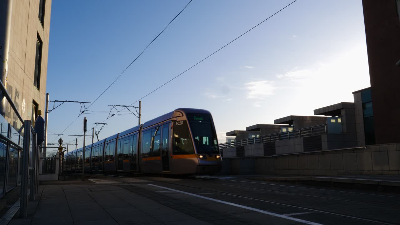 Tram moderno arriva e parte in una stazione urbana