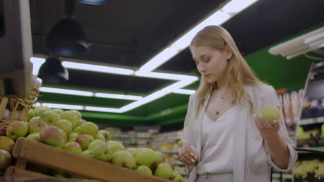 mujer seleccionando manzanas rojas frescas en la tienda de comestibles supermercado venta de compras mercado de comida tomando la elección de manzanas niña con bolsa comprando manzanas en la canasta de compras