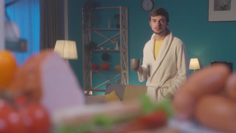 man drinking coffee in a robe at home