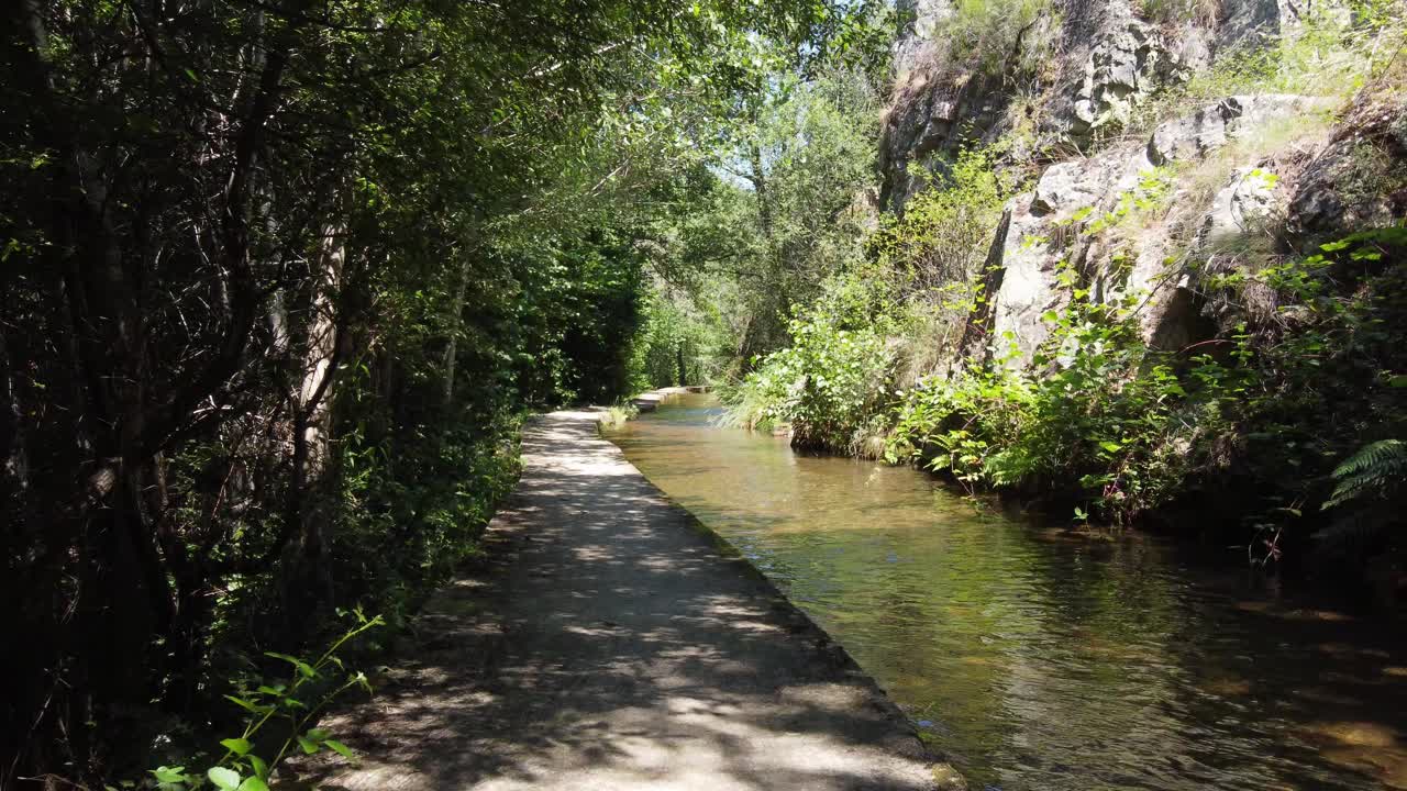 volando suavemente hacia atrás sobre un canal de agua en las montañas