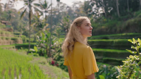 Schöne-Frau-Im-Reisfeld-In-Gelbem-Kleid-Genießt-Den-Urlaub-Und-Erkundet-Den-Blick-Auf-Die-Reisterrassenfarm,-Besichtigungsreise-Durch-Bali,-Indonesien,-4k