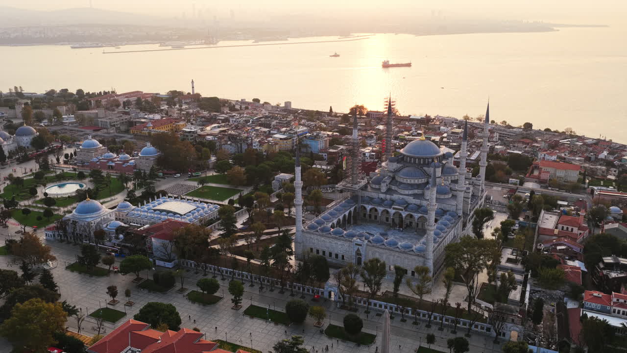 The Blue Mosque glows in warm evening light as the sun reflects on the Sea of Marmara, showcasing Istanbul’s rich history and serene coastline