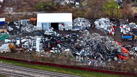 a large scrap metal yard with heaps of debris, industrial waste, and recycling materials