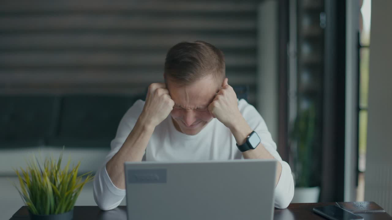 Frustrated young man sitting in front of his laptop after reading bad news, says no. Finance crisis