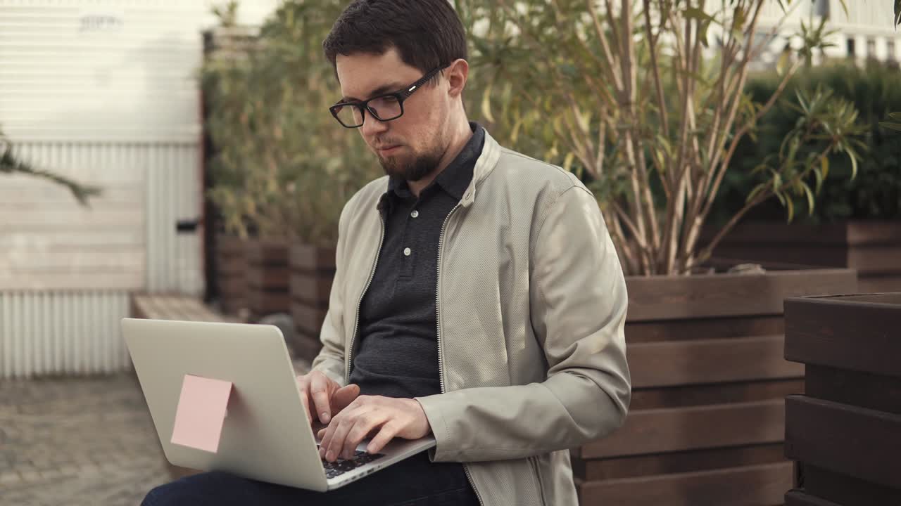 young business man developing a startup project on a laptop sitting on a bench