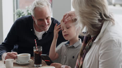 family using smartphone in cafe