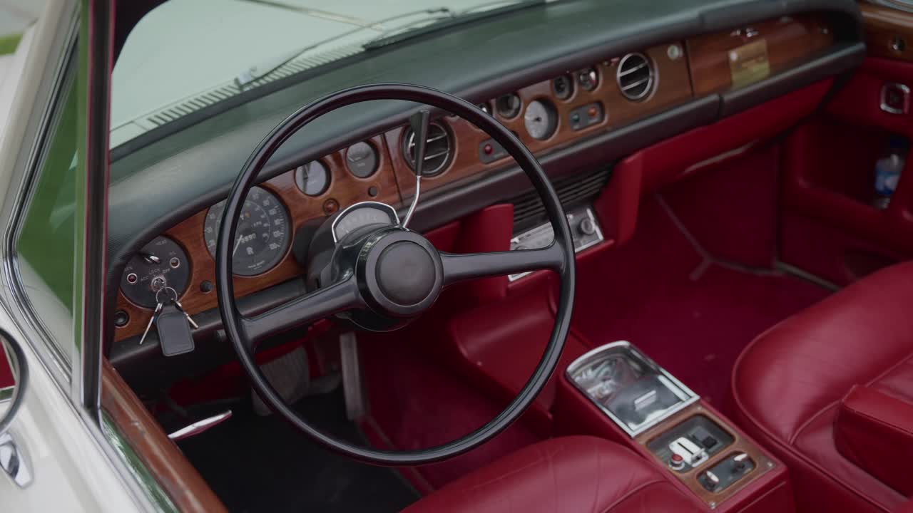 빨간색 가죽 시트, 스티어링 휠, 나무 대시보드 디테일이 돋보이는 빈티지 클래식 자동차 내부