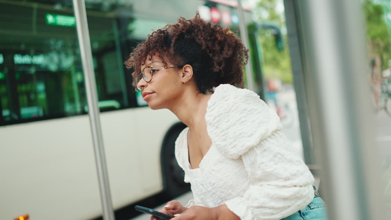 Woman using phone at bus stop