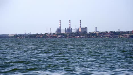 general wide view of an oil industry facility on the shore of a polluted lake
