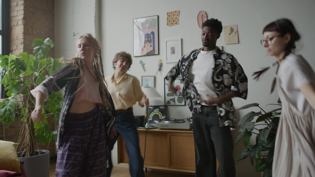 Group of Young Energetic Friends Dancing near Turntable at Home Party