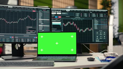 stock market metrics diagrams displayed on green screen laptop in office