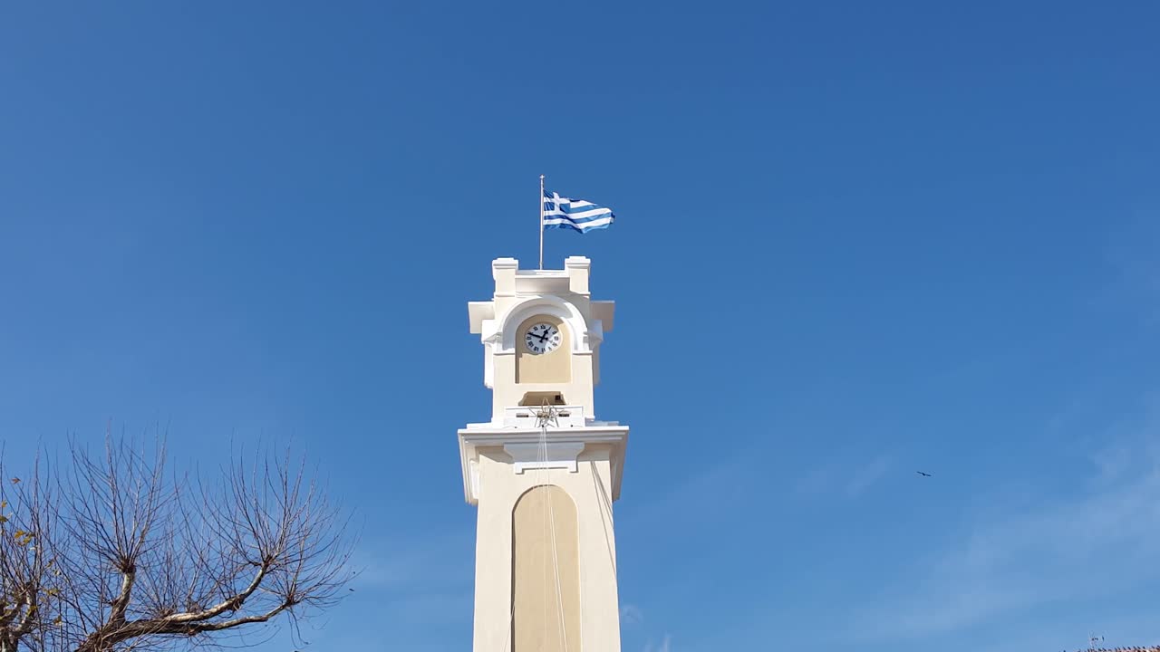 Clock tower in Xanthi Greece, Greek Flag Waving on top, City Square Plaza