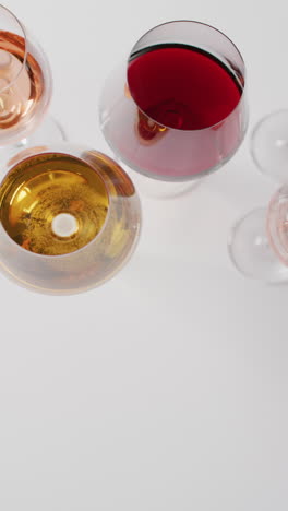 vertcal video of diverse wine in glasses on white table