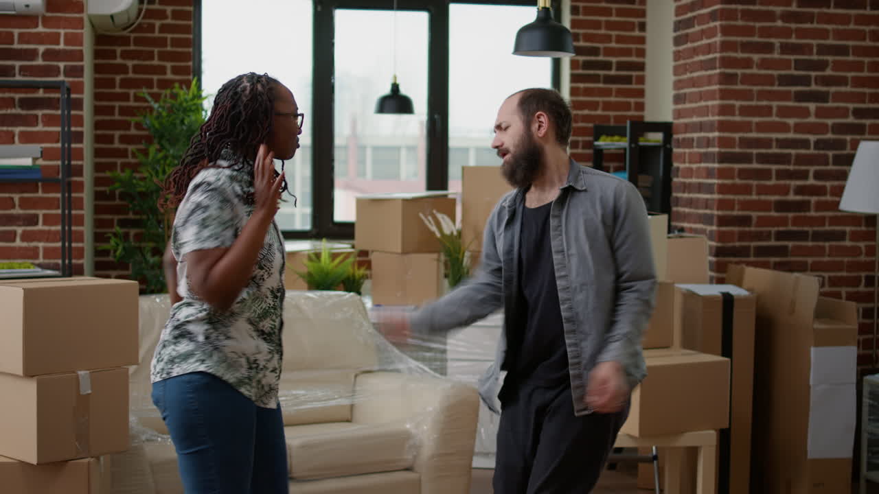 Diverse couple dancing in new home celebrating moving in together