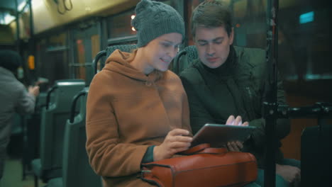 young people using tablet computer in the bus