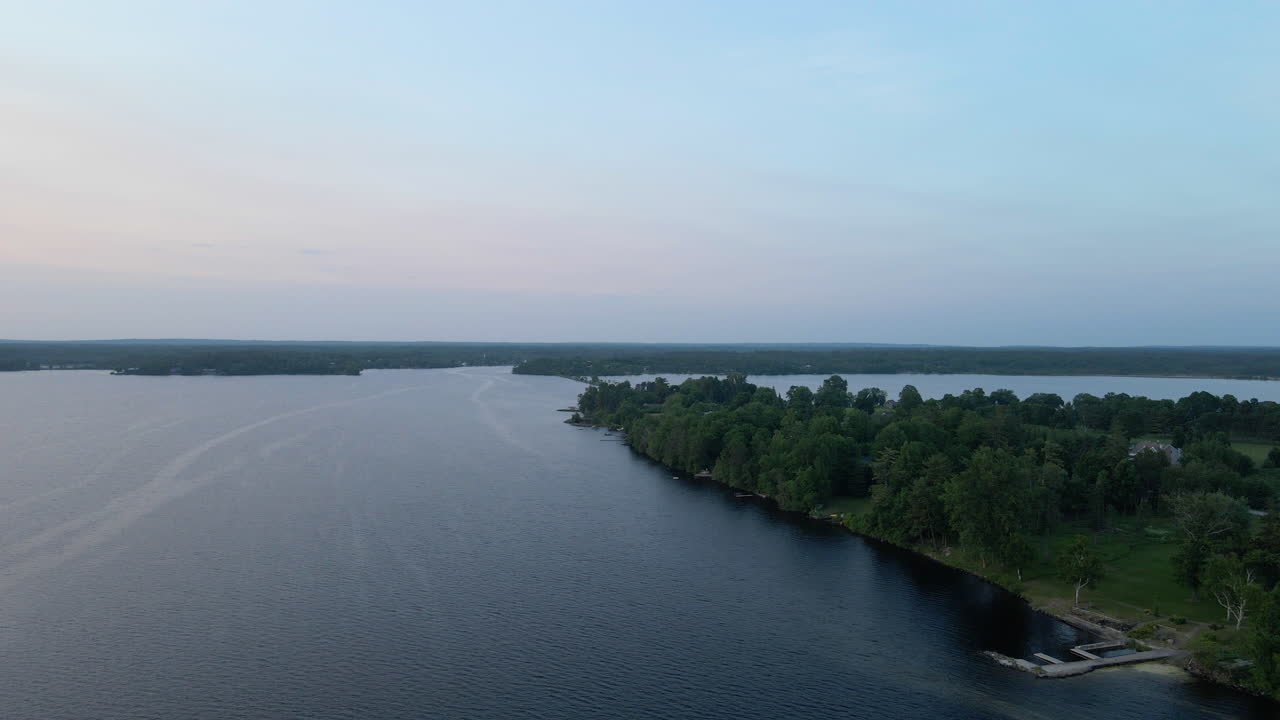 Ripresa aerea su una foresta insulare ai margini di un lago calmo in una giornata limpida. Calabogie Ontario.