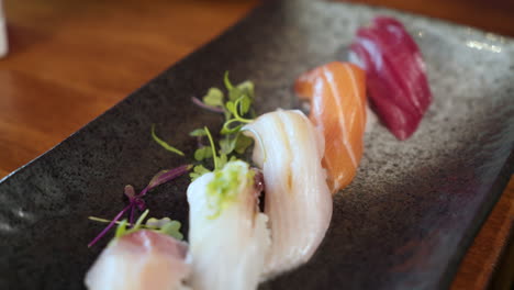 línea de sushi nigiri colorido en plato de sushi japonés tradicional, control deslizante de cerca 4k
