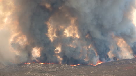 mesmerizing view over a frightening wildfire with heavy black smoke rising