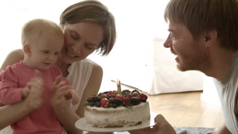 happy mom and dad celebrating birthday of baby girl