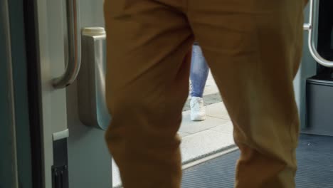 from inside train, passengers legs and feet boarding commuter train