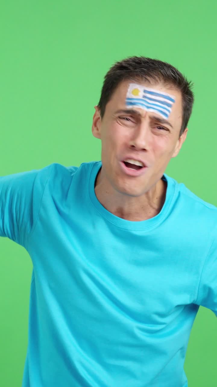 Man cheering for Uruguay during a match that is lost