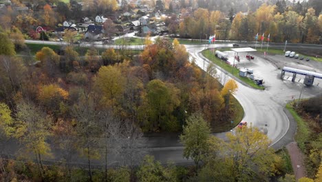 top down view, petrol station surrounded by trees, fall season colors, parallax motion