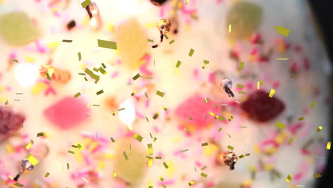 confetti falling animation over colorful candies and sprinkles, creating festive atmosphere