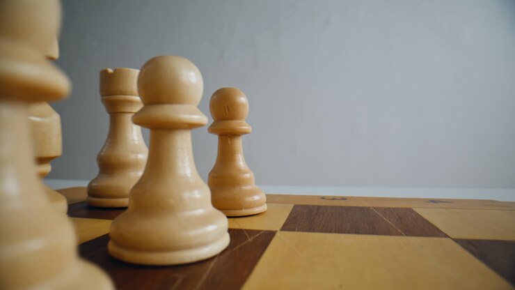 Closeup first chess move in logic game. Man fingers playing with white figures