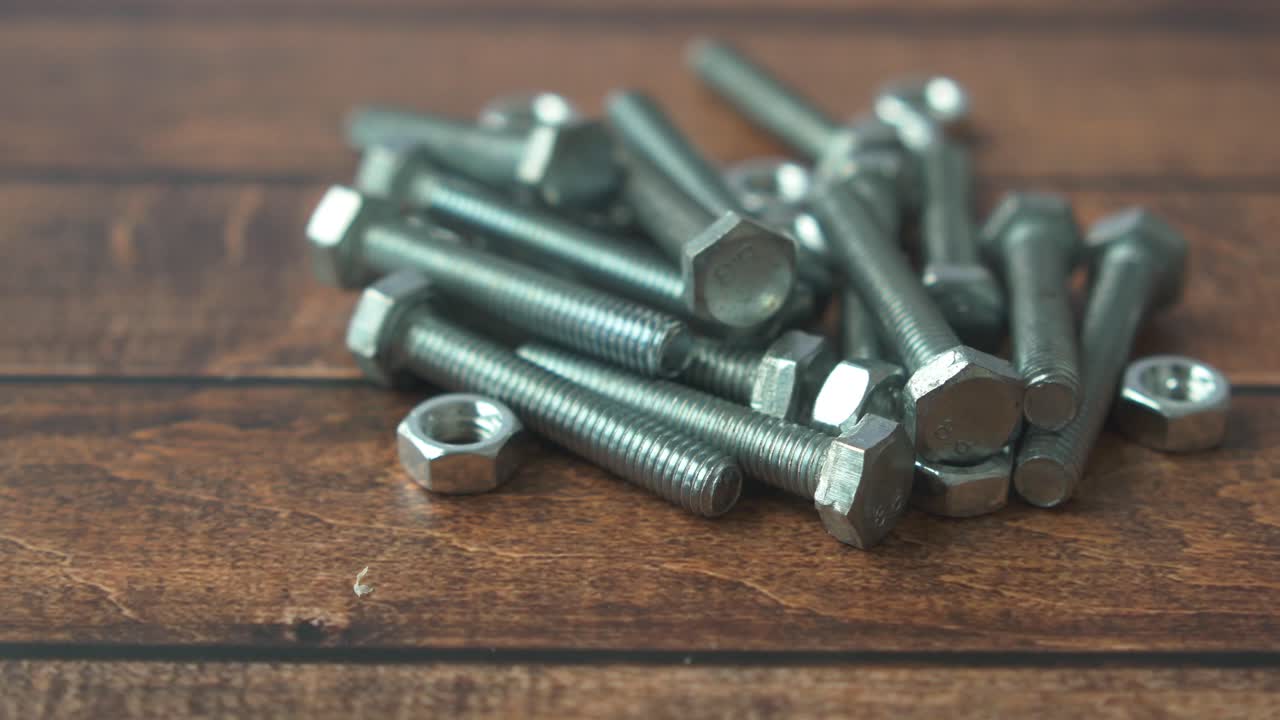 pernos y tuercas en superficie de madera