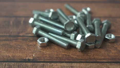 bolts and nuts on wooden surface