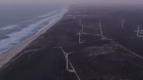 windturbines at praia do norte portugal during morning with low clouds, aerial