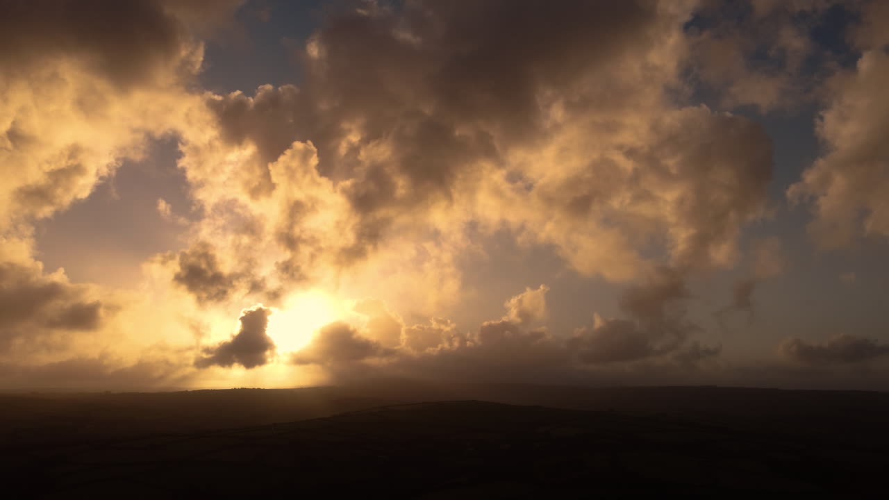 Beautiful Morning Sunrise Scene Across Exmoor with Varied Cloudscape with Dark and Bright Clouds with SunRays Piercing Through Hazy Atmosphere 4K