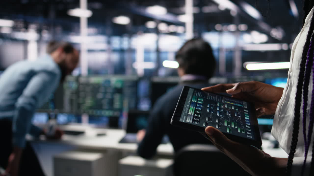 Close Up Of Data Center Engineer Using Tablet To Review Code